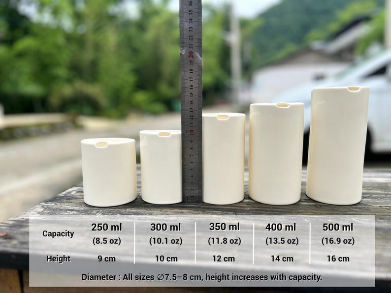 May include: Five off-white cylindrical pump bottles of varying heights arranged in a row. A metal ruler stands vertically behind them for scale. A chart below lists capacities from 8.5 oz to 16.9 oz and heights from 9 cm to 16 cm, with a diameter of 3 inches.