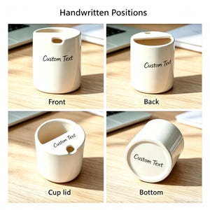 May include: A white ceramic cup with a lid featuring a small circular opening. The cup displays the words Custom Text in black script on the front, back, lid, and bottom. The design includes a semi-circular cutout on the lid for access.