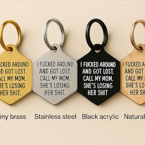 May include: Four hexagonal keyrings in shiny brass, stainless steel, black acrylic, and natural wood. Each keyring has a ring and the text: "I FUCKED AROUND AND GOT LOST. CALL MY MOM. SHE'S LOSING HER SHIT."