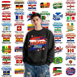 May include: A black sweatshirt with a Croatian flag design and the text "CROATIA 2026" in white and blue. The image also features flags and text related to the World Cup 2026.