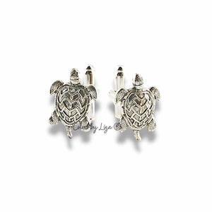May include: Silver turtle cufflinks. The cufflinks are detailed with a textured turtle design.