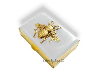 Caixa de pílulas de abelha de ouro antigo incrustada em esmalte branco brilhante pintado à mão, inspirada na Art Déco, opções de personalização e cores disponíveis