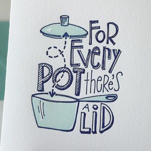 May include: A white card with blue ink lettering that reads "For Every Pot There's A Lid". The card features a hand-drawn illustration of a pot and lid.