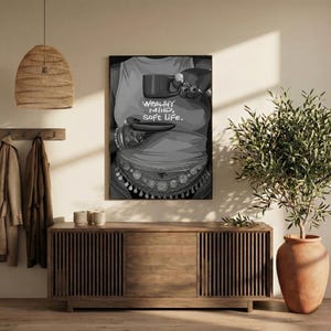 May include: Black and white art print featuring a person holding a cup and saucer. The person is wearing a tank top with the words "WEALTHY MIND, SOFT LIFE." The person is also wearing jewelry around the waist and on the wrists.