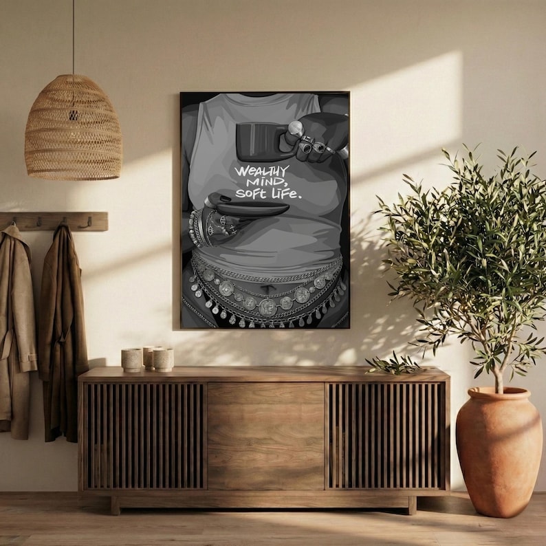 May include: Black and white art print featuring a person holding a cup and saucer. The person is wearing a tank top with the words "WEALTHY MIND, SOFT LIFE." The person is also wearing jewelry around the waist and on the wrists.