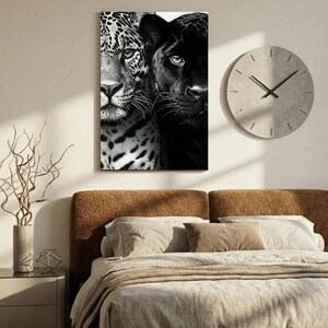 Peut inclure: Une impression sur toile en noir et blanc repr&eacute;sentant les visages d'un jaguar et d'une panth&egrave;re. Le jaguar, avec un pelage tachet&eacute;, est &agrave; gauche, et la panth&egrave;re &agrave; droite. Une horloge ronde grise est accroch&eacute;e au mur.