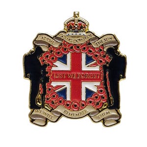 Peut inclure: Une épingle dorée avec un drapeau britannique rouge, blanc et bleu entouré d'une couronne de coquelicots rouges. L'épingle porte le texte "At the going down of the sun... Lest We Forget... We will remember them." et une couronne en haut.