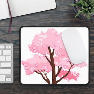 May include: A pink cherry blossom tree with a white background on a black mouse mat.