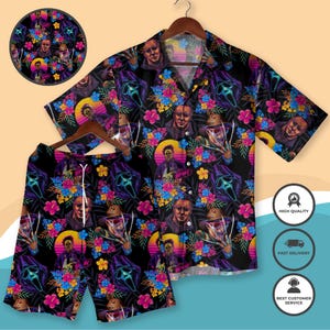 Pode incluir: Um conjunto de camisa de manga curta com botões e calções a condizer, com fundo preto, um padrão floral tropical vibrante e gráficos repetidos de personagens de filmes de terror em tons néon de rosa, azul e amarelo.