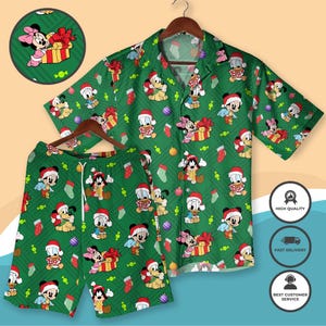 Puede incluir: Conjunto de camisa y pantalón corto verde con temática navideña. El conjunto presenta un patrón repetido de Mickey Mouse, Minnie Mouse, Donald Duck y Pluto con gorros de Papá Noel, junto con cajas de regalo y calcetines navideños.