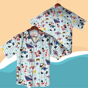 May include: Short-sleeved button-down shirt featuring a nautical-themed pattern with cartoon characters, ships, anchors, and stars on a light blue and white striped background. The shirt is displayed on a wooden hanger.