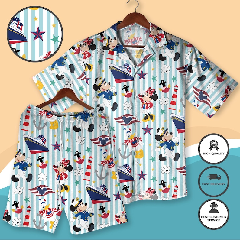 May include: A matching shirt and shorts set featuring a nautical theme with cartoon characters. The light blue fabric has vertical stripes and is patterned with ships, stars, anchors, and cartoon characters in sailor outfits. The shirt has short sleeves and a button-down front.