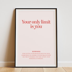 Könnte beinhalten: Gerahmter Druck mit dem Text "Your only limit is you" in Rot auf hellrosa Hintergrund. Darunter eine Erinnerung mit zusätzlichem Text. Der Rahmen ist schwarz, und der Druck wird auf einem Holzboden präsentiert.