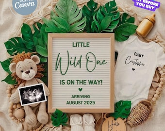 Peut inclure: Annonce de grossesse sur le thème de la jungle. Le texte "LITTLE Wild One IS ON THE WAY! ARRIVING AUGUST 2025" est affiché sur un tableau de lettres. L'image comprend un lion en peluche, des vêtements de bébé et une échographie.