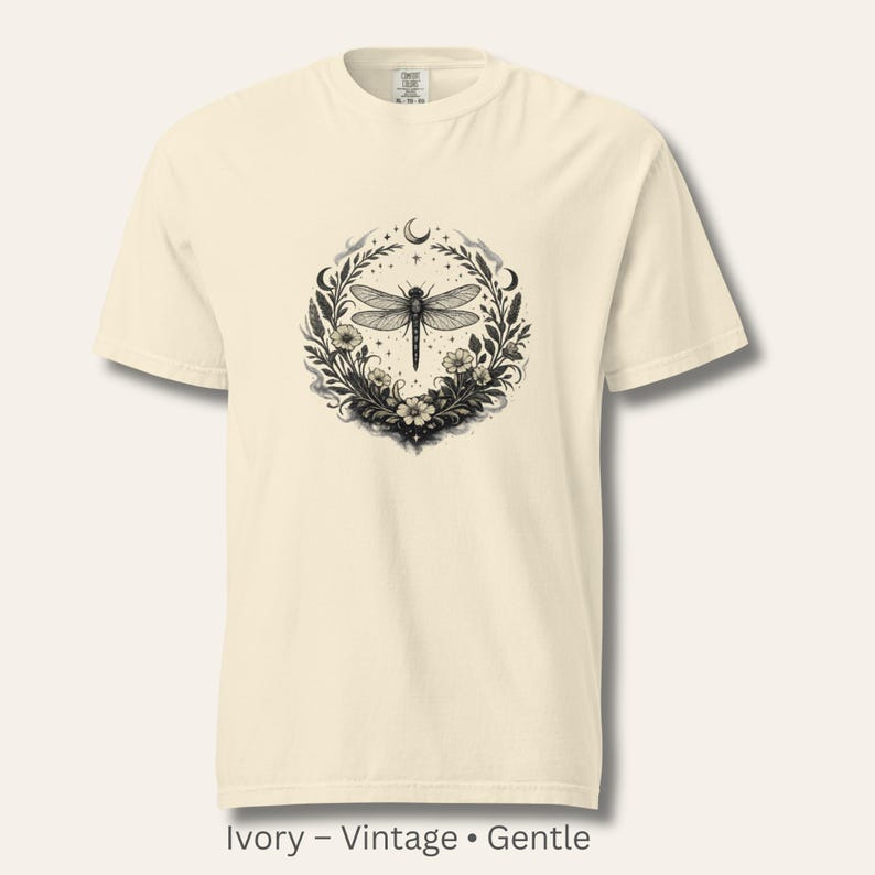 Flat lay of a Comfort Colors 1717 t-shirt in Ivory with the Dragonfly Sigil and botanical artwork. Warm, vintage, parchment-like tone. Garment-dyed cotton with soft texture. Perfect for intuitive women and symbolic, nature-coded style.