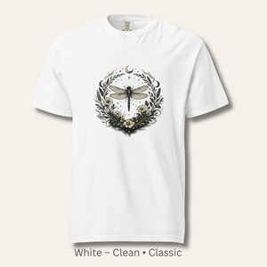 Flat lay of a Comfort Colors 1717 t-shirt in White featuring the Dragonfly Sigil with botanical linework and crescent moon. Clean, classic, symbolic design. Vintage-washed cotton ideal for witchy, botanical, and nature-inspired wardrobes.