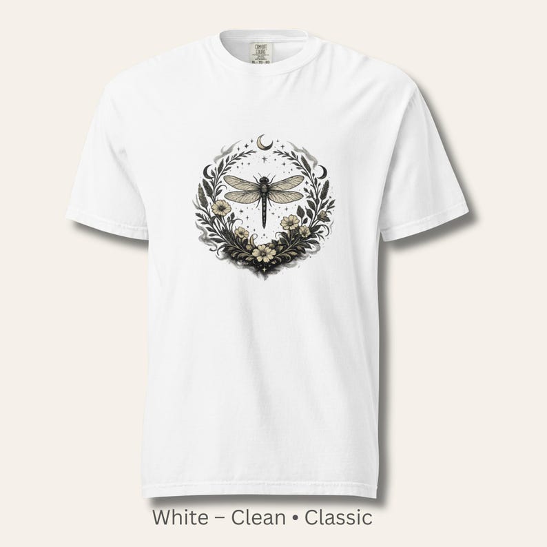 Flat lay of a Comfort Colors 1717 t-shirt in White featuring the Dragonfly Sigil with botanical linework and crescent moon. Clean, classic, symbolic design. Vintage-washed cotton ideal for witchy, botanical, and nature-inspired wardrobes.