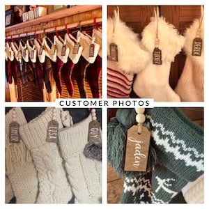 May include: A collection of personalized Christmas stockings with wooden tags featuring names like "Jaden", "Lisa", "Guy", "Taylor", "Turner", "Derek", "Christine", and "Averi".