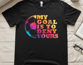 Könnte beinhalten: Schwarzes T-Shirt mit einem farbenfrohen Fußball-Grafik und dem Text "MY GOAL IS TO DENY YOURS". Das Fußball-Design hat einen Farbverlauf aus Blau, Lila, Gelb und Orange.