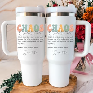 May include: Two white stainless steel tumblers with handles and lids. The text reads: Chaos Coordinator, a definition of someone who solves problems, and the name Samantha. The design features muted peach, sage green, and yellow lettering.