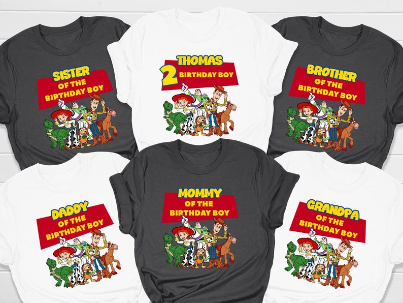 May include: Set of 6 white and grey t-shirts with a Toy Story theme. The shirts feature different text and images, including "Sister of the Birthday Boy", "Brother of the Birthday Boy", "Daddy of the Birthday Boy", "Mommy of the Birthday Boy", "Grandpa of the Birthday Boy", and "Thomas 2 Birthday Boy".