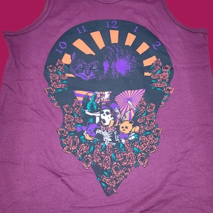 May include: A maroon tank top with a graphic print of a black cat with purple accents, surrounded by roses and a clock face with Roman numerals. The graphic also includes a skull with a crown and two bears.