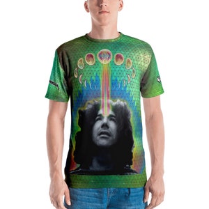 May include: A green t-shirt with a psychedelic design featuring a man's face with a rainbow beam of light coming from his third eye. The design also includes a geometric pattern and a crescent moon.