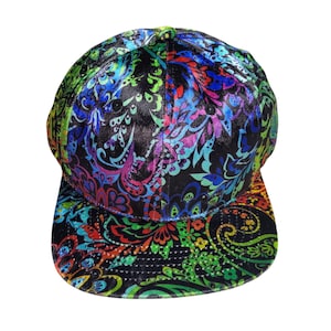 May include: A colorful baseball cap with a paisley pattern. The cap features a black background with vibrant accents of red, green, blue, and purple. The brim and crown are covered in the intricate design, creating a bold and eye-catching accessory.