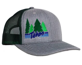 May include: A gray and green trucker hat with a green and blue embroidered design of pine trees and the word "Tahoe".