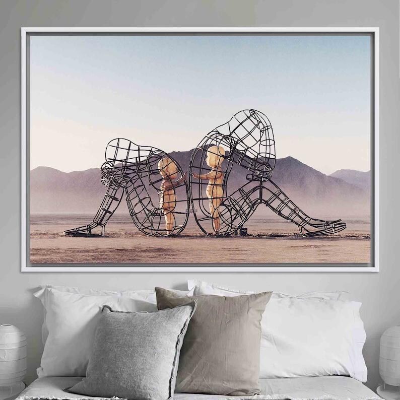 May include: A black metal sculpture of a woman and two children, all standing in a desert landscape. The sculpture is made of wire and is very detailed.