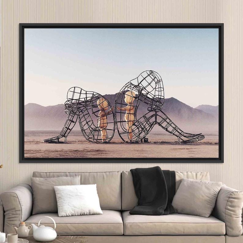 May include: A black and white photograph of three metal sculptures in the shape of people. The sculptures are standing in a desert landscape. The sculptures are made of wire and are very detailed. The sculptures are a mother and two children.