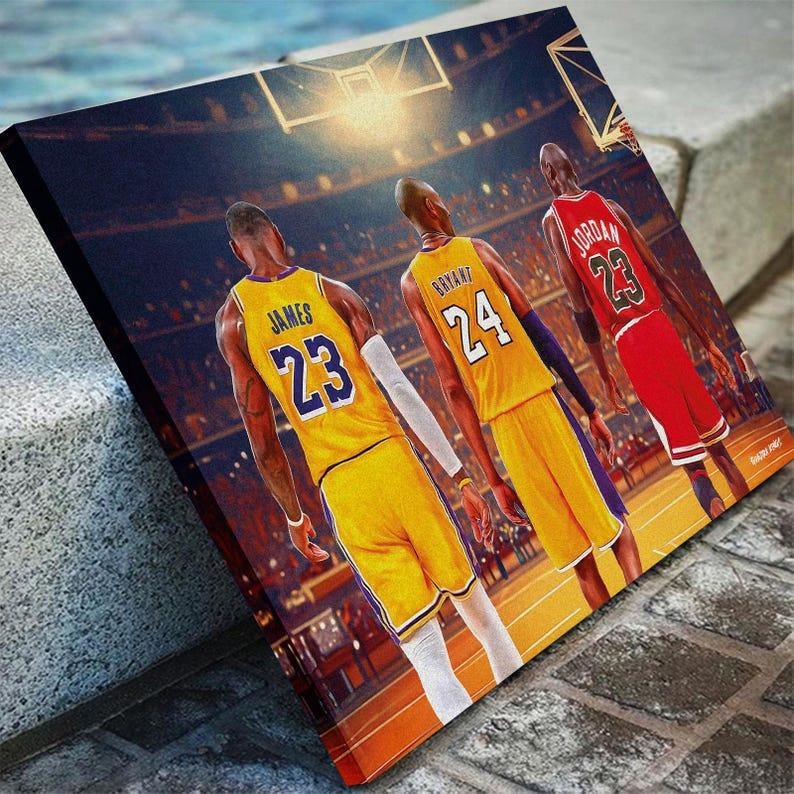 May include: Canvas print featuring three basketball players in action. The players are wearing jerseys with the numbers 23 and 24. The background shows a basketball court and spectators. The canvas is displayed at an angle.
