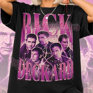 May include: Black unisex t-shirt with a purple graphic design featuring the text "RICK DECKARD" and images of several men. The words "Unisex Shirt" are printed in pink script at the bottom. A retro-style design.