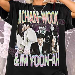 Puede incluir: Camiseta unisex negra con un diseño retro que muestra los nombres "JICHAN-WOOK" y "& IM YOON-AH" y un collage de imágenes. Las palabras "Unisex Shirt" están impresas en la parte inferior. La camiseta la lleva una persona.