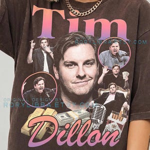 May include: A brown t-shirt featuring a large graphic print of Tim Dillon. The design includes multiple photos of the person, gold bars, a stack of cash, a vintage microphone, and a pack of cigarettes. The text reads Tim Dillon and RORYLIBRA.ETSY.COM.
