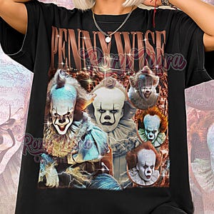 Puede incluir: Camiseta unisex negra con un collage de Pennywise el payaso de la película "IT". La camiseta tiene las palabras "Pennywise" en una fuente marrón desgastada. Las palabras "Unisex Shirt" están en la parte inferior.