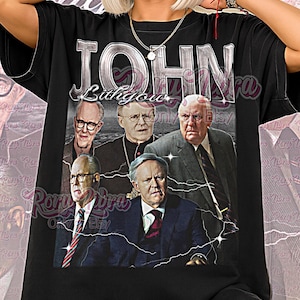 Op de afbeelding: Zwart unisex T-shirt met een afbeelding van John Lithgow en de tekst "John Lithgow". Het ontwerp heeft een vintage stijl met een bliksemeffect. De woorden "Unisex Shirt" staan onderaan gedrukt.