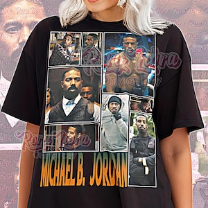 May include: Black unisex t-shirt with a collage of images of Michael B. Jordan. The shirt has the text "MICHAEL B. JORDAN" in orange and green. The words "Unisex Shirt" are also printed on the shirt.