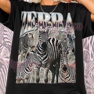 May include: Black unisex shirt featuring a graphic of several zebras with the text "ZEBRA Equus quagga". The shirt has a vintage style design and the words "Unisex Shirt" at the bottom.