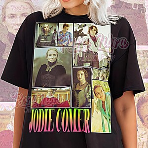 May include: Black unisex shirt featuring a collage of images of Jodie Comer. The shirt has the text "JODIE COMER" in a gradient font. The words "Unisex Shirt" are also printed on the shirt.