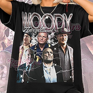 May include: Black unisex t-shirt featuring a graphic of Woody Harrelson and the text "WOODY Harrelson". The shirt has a crew neck and short sleeves. The words "Unisex Shirt" are printed at the bottom of the shirt.