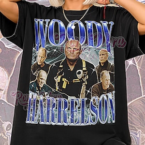 May include: Black unisex t-shirt featuring a graphic of Woody Harrelson with the text "Woody Harrelson". The design includes multiple images of the actor. The words "Unisex Shirt" are printed at the bottom.
