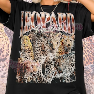 Puede incluir: Camiseta unisex negra con un gráfico de leopardo y el texto "LEOPARD Panthera". El diseño incluye múltiples imágenes de leopardo. Las palabras "Unisex Shirt" están impresas en la parte inferior en rosa.