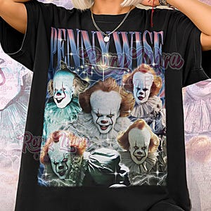 Puede incluir: Camiseta unisex negra con un gráfico de Pennywise el payaso de la película "It". El diseño incluye múltiples imágenes del payaso con maquillaje blanco, pelo rojo y una sonrisa siniestra. La camiseta tiene el texto "Pennywise" en la parte superior.