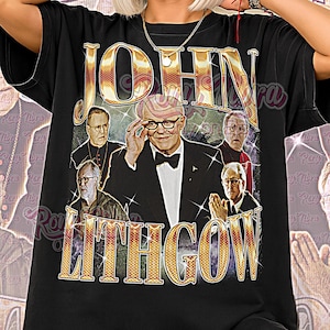 Op de afbeelding: Zwart unisex T-shirt met een retro graphic van John Lithgow. Het ontwerp toont de naam "JOHN LITHGOW" in gouden letters, samen met afbeeldingen van de acteur. De woorden "Unisex Shirt" staan onderaan het T-shirt.