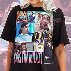 May include: Black unisex t-shirt with a collage of images and the name "CRISTIN MILIOTI" in a colourful font. The shirt also has the text "Unisex Shirt" at the bottom. The person in the image is wearing sunglasses.