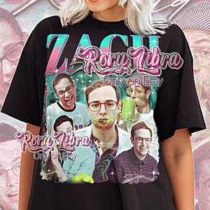 May include: Black unisex t-shirt featuring a graphic of multiple people with glasses and the text "ZACH Rory Libra Only on Etsy." The shirt has a vintage aesthetic with a pink and teal color scheme. The words "Unisex Shirt" are at the bottom.