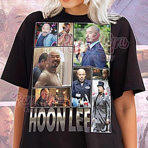 May include: Black unisex t-shirt featuring a collage of images of Hoon Lee. The shirt has the name "HOON LEE" in silver block letters. The words "Unisex Shirt" are printed in pink script at the bottom.