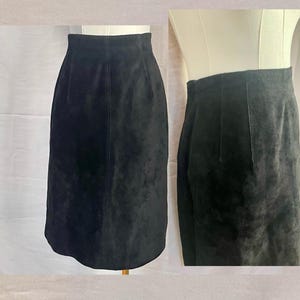 May include: A black suede skirt with a straight silhouette and a knee-length hem.