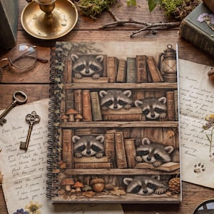 Puede incluir: Un cuaderno de espiral con una ilustración detallada de mapaches asomándose entre filas de libros antiguos en estantes de madera, decorado con pequeñas setas y bellotas, sobre una paleta de colores cálidos, rústicos y terrosos.